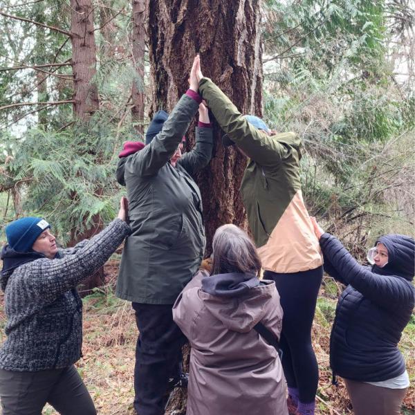 Group of CYC students gathered in a bridge-making game in the forest. 